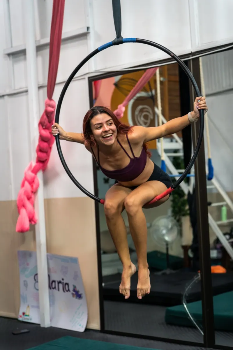 Alumna de Volaria sonriendo, sentada en la lira del estudio